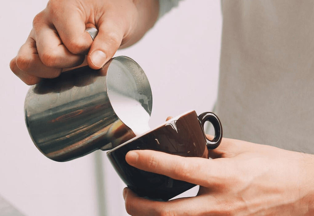 pouring cream into a coffee cup